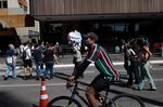 A cotton candy seller passes by visitors on Paulista Avenue in Sao Paulo, Brazil.