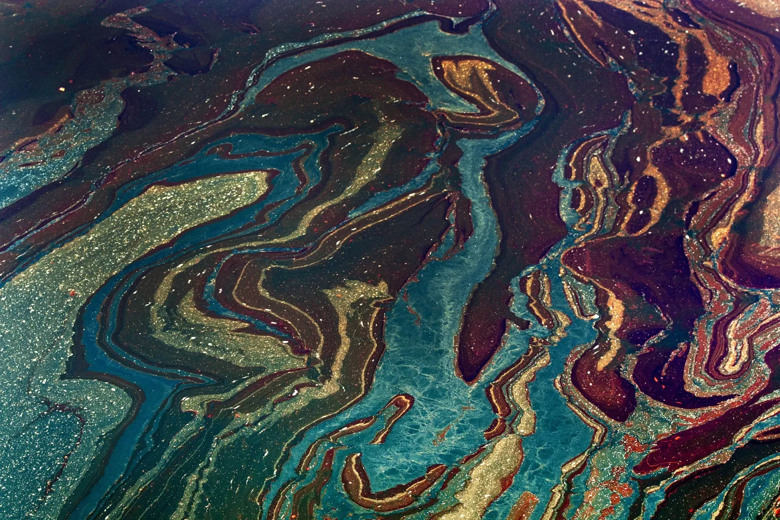 Oil floats in the Gulf of Mexico near Orange Beach, Alabama, U.S., on Friday, June 18, 2010. The BP Plc oil spill, which began when the leased Transocean Deepwater Horizon oil rig exploded on April 20, is gushing as much as 60,000 barrels of oil a day into the Gulf of Mexico, the government said.