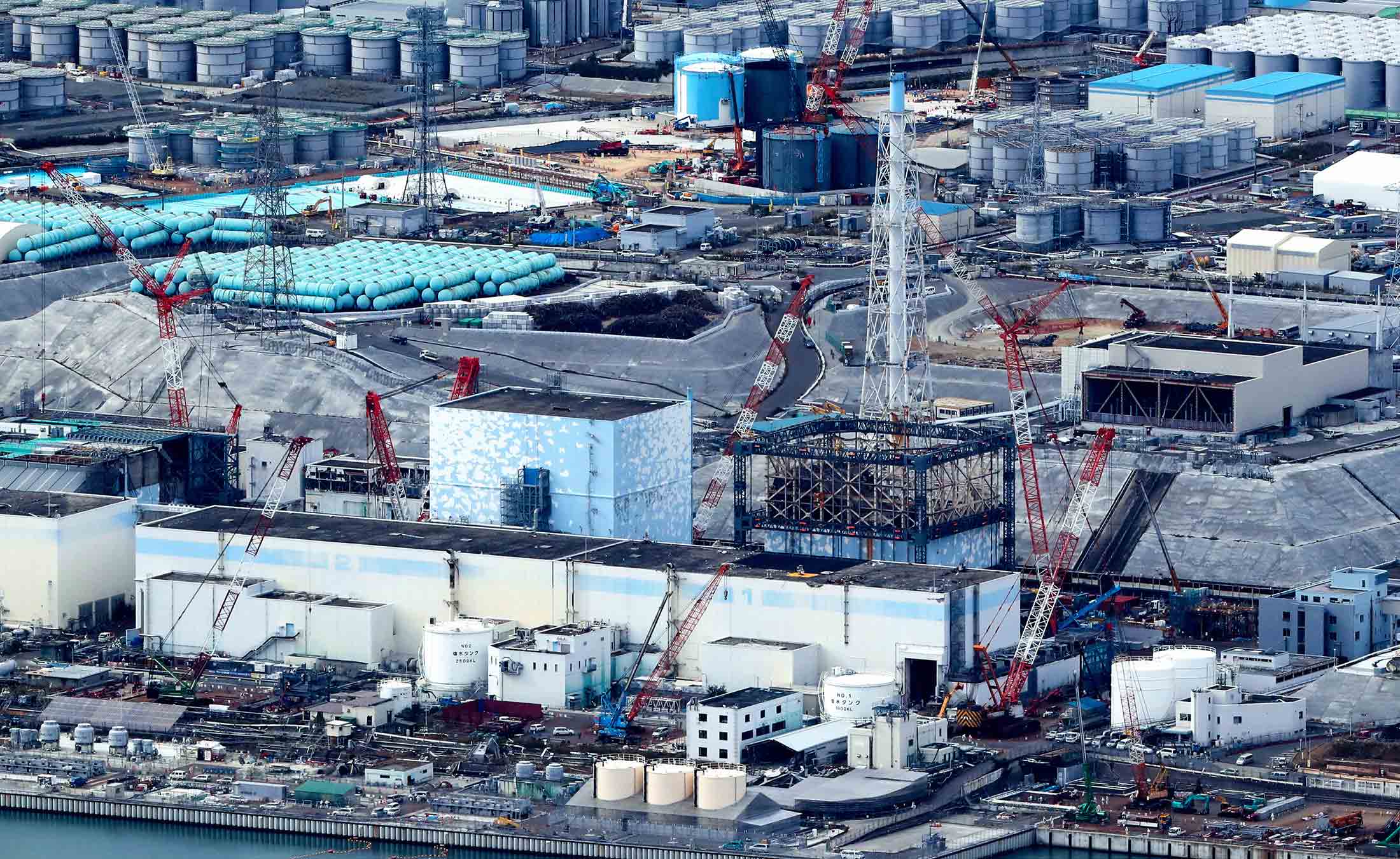 In this aerial image, the No. 1 reactor building (R) at the crippled Fukushima Daiichi Nuclear Power Plant is completely exposed after the last of 18 temporary protective covers was removed on November 7, 2016 in Okuma, Fukushima, Japan.
