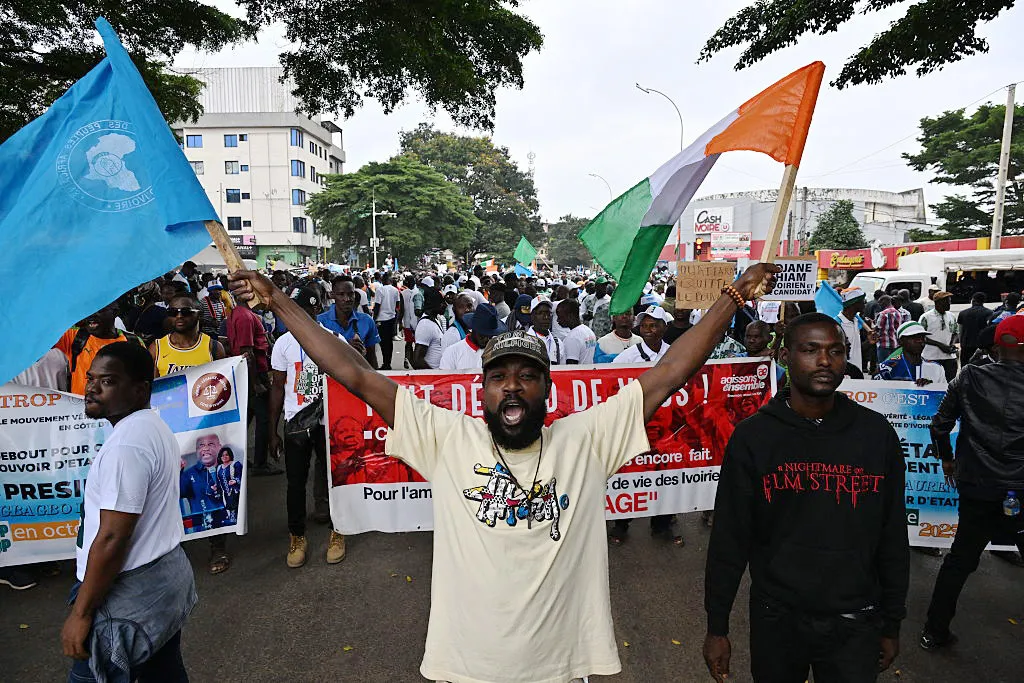 An opposition supporter&nbsp;waves a flag of Ivory Coast and the African People's Party of Ivory Coast,&nbsp;during a march for inclusive elections in Abidjan, on Aug.&nbsp;9.