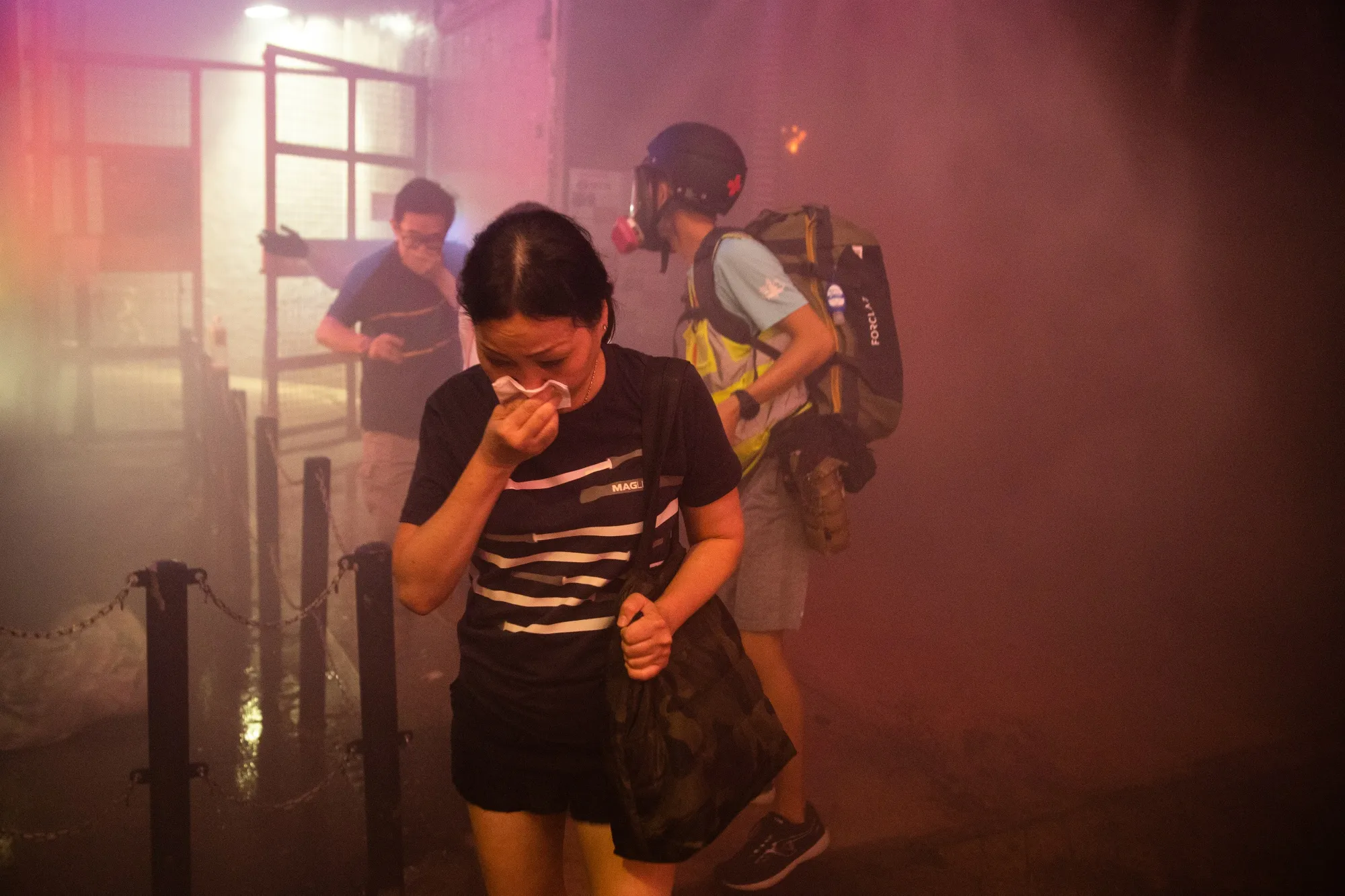 Pedestrians cover their face after demonstrators set fire to a barricade during a protest in Hong Kong, Oct. 4.