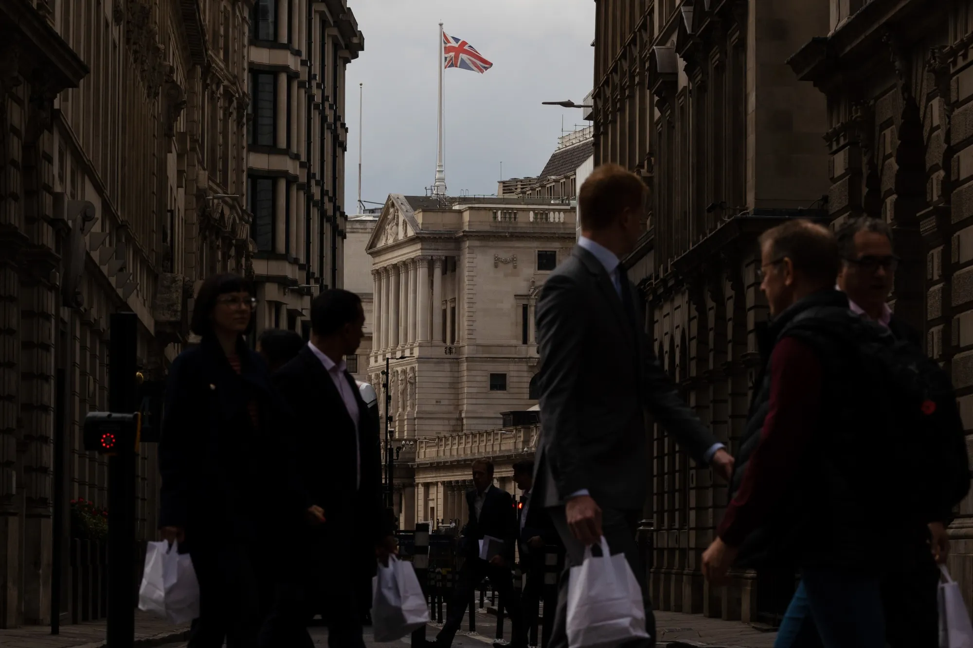 City workers walk near the Bank of England (BOE) in the City of London.