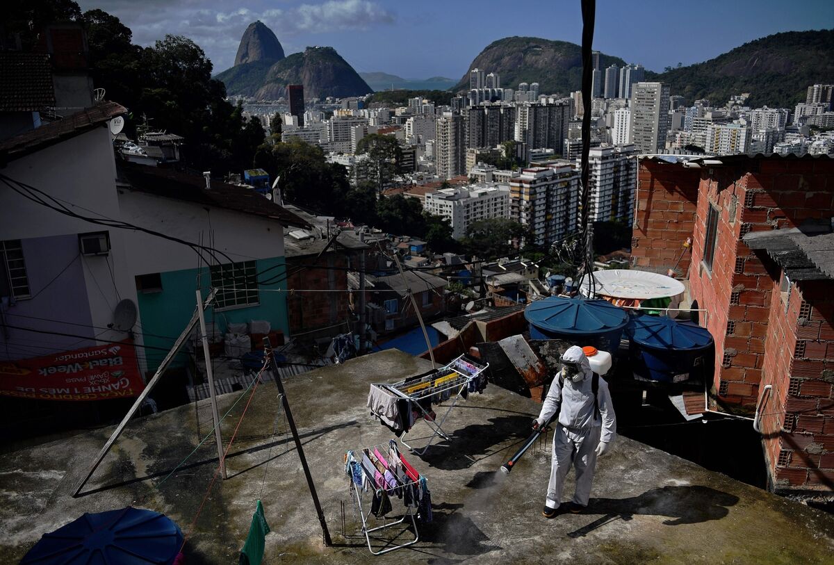 Ένας εθελοντής απολυμαίνει μια περιοχή στον τελευταίο όροφο μέσα στη Santa Marta Favela, στο Ρίο ντε Τζανέιρο.  Μεγάλο μέρος του πληθυσμού στη Λατινική Αμερική ζει σε πολυσύχναστες συνθήκες όπου η κοινωνική απόσταση είναι δύσκολη.  Φωτογράφος: Carl de Souza / AFP / Getty Images