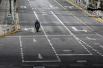 A delivery worker travels along a near-empty road during a lockdown in Shanghai, China. Demand for fuel has been slashed as cities lock down to slow the spread of Covid-19.