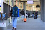 Travelers wheel luggage after arriving on a flight at Berlin Schoenefeld Airport in Schoenefeld, Germany, on June 15.