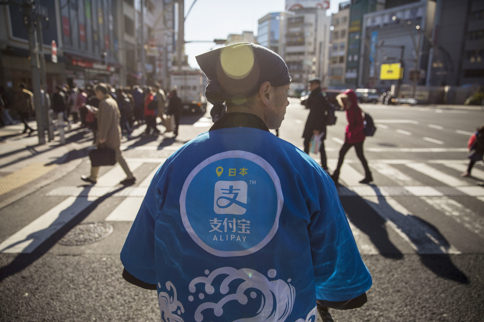 A staff member wearing a uniform featuring the logo for Ant Financial Services Group's Alipay.