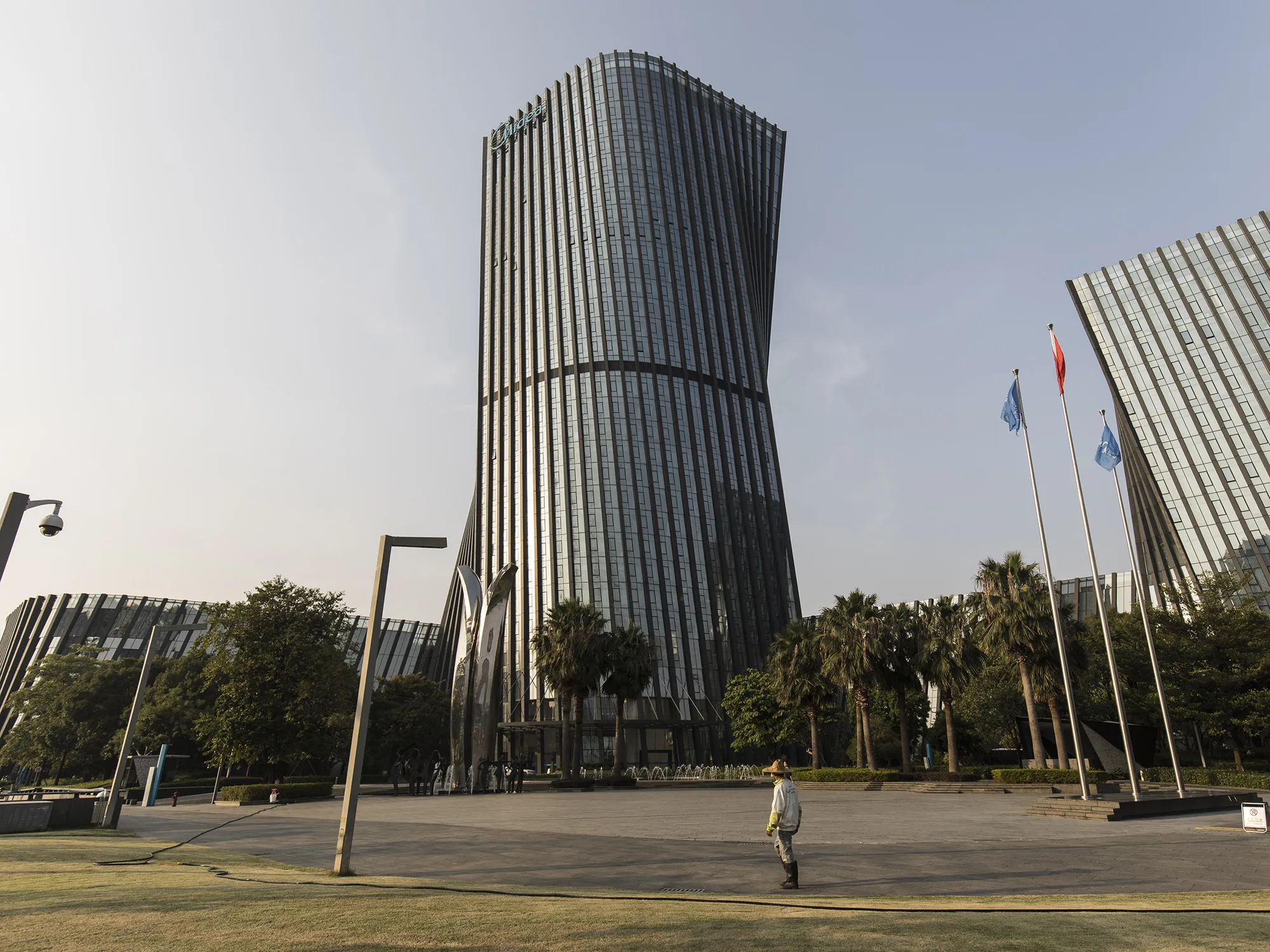 A pedestrian walks past the Midea Group Co. headquarters in Foshan, China.