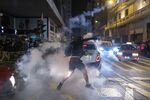 A demonstrator throws a tear gas sub-munition towards riot police during a protest in the Tsim Sha Tsui district of Hong Kong, China, on Wednesday, Dec. 25, 2019.