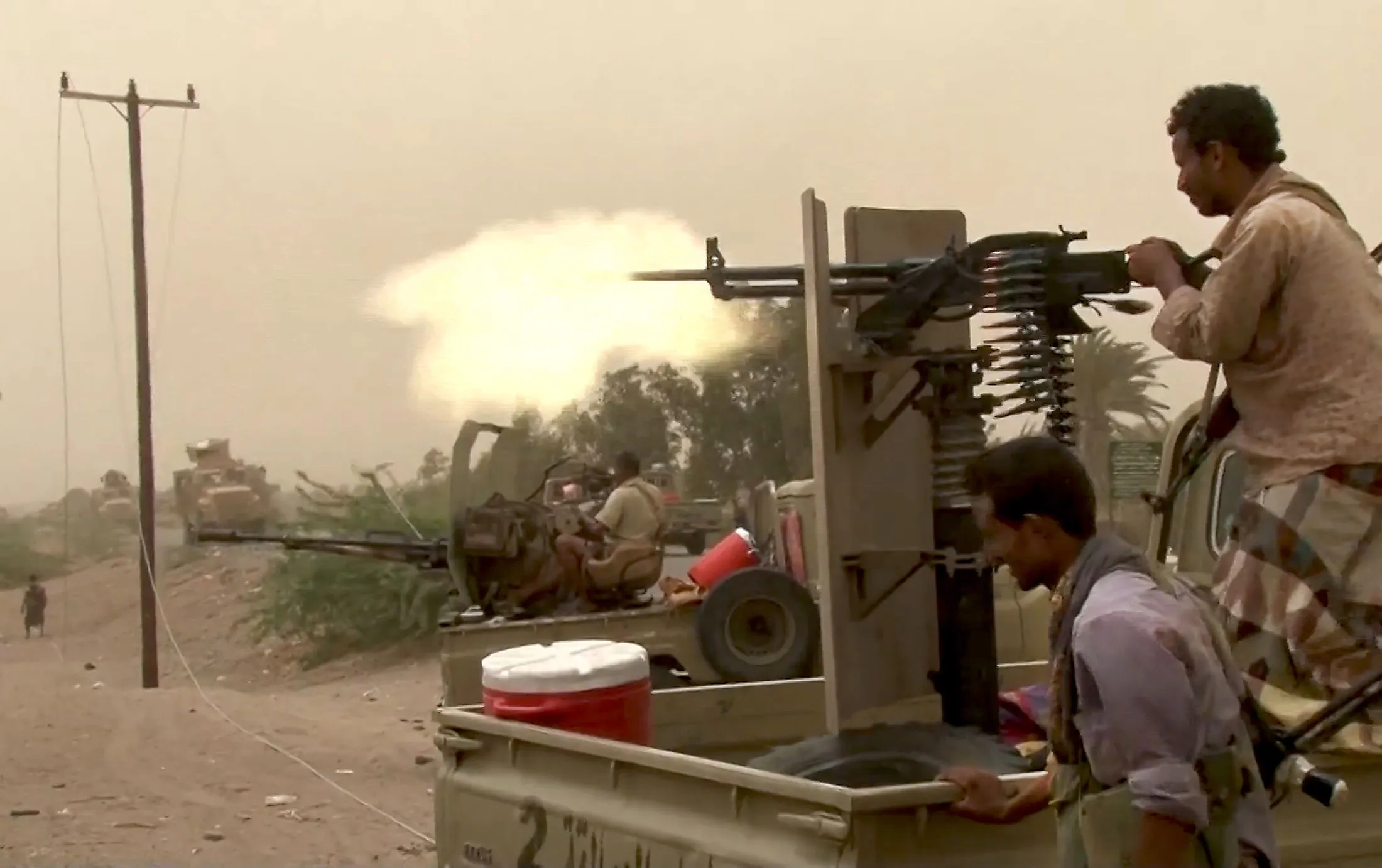 This image grab taken from a AFPTV video shows Yemeni pro-government forces firing a heavy machine gun at the south of Hodeida airport, in Yemen's Hodeida province on June 15.