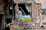 A Ukrainian flag hangs from a balcony of a destroyed residential building in Irpin, Ukraine.