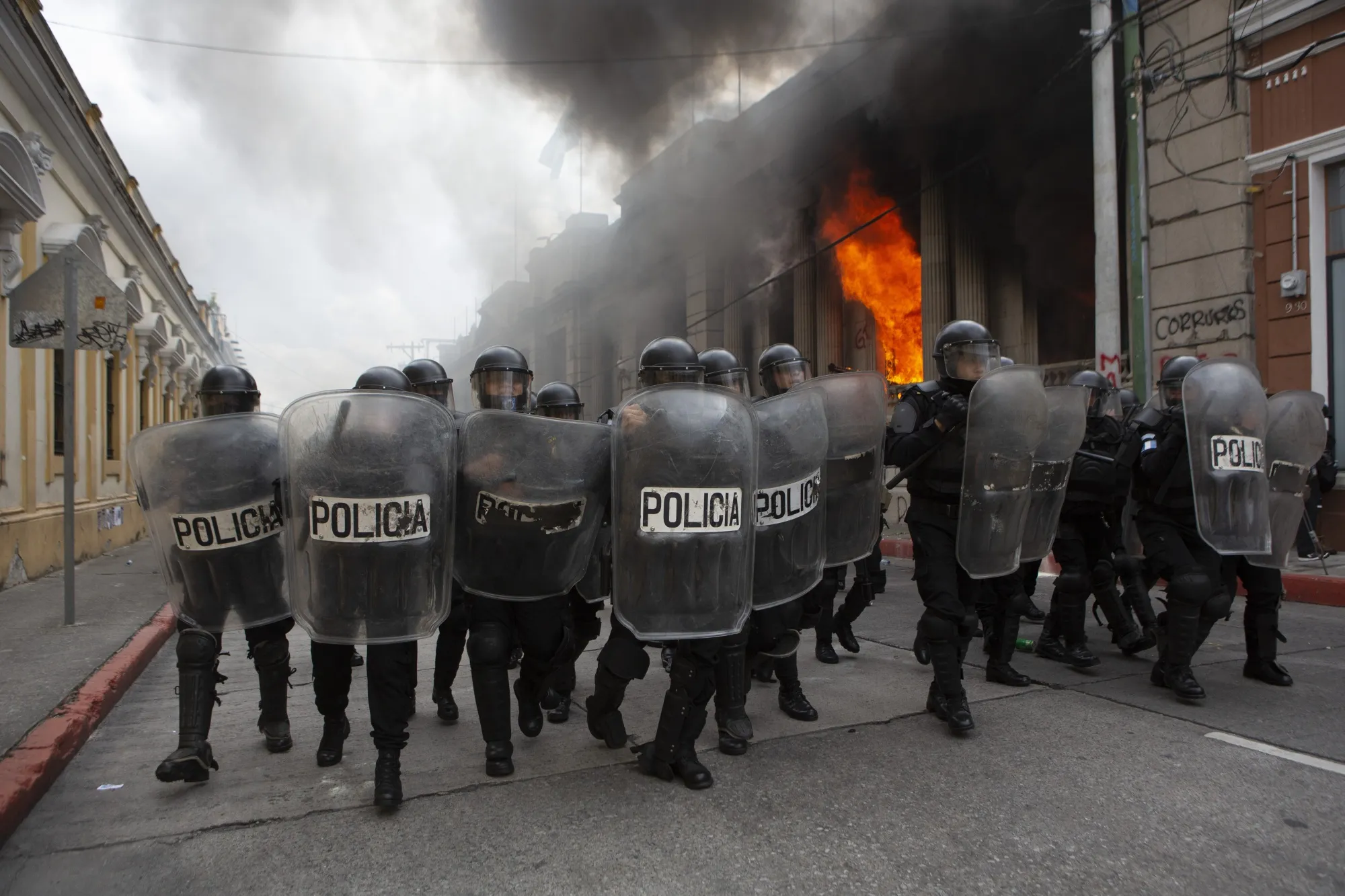 Riot police form a cordon as flames shoot out from the Congress building after protesters set a part of the building on fire, in Guatemala City, Nov. 21.