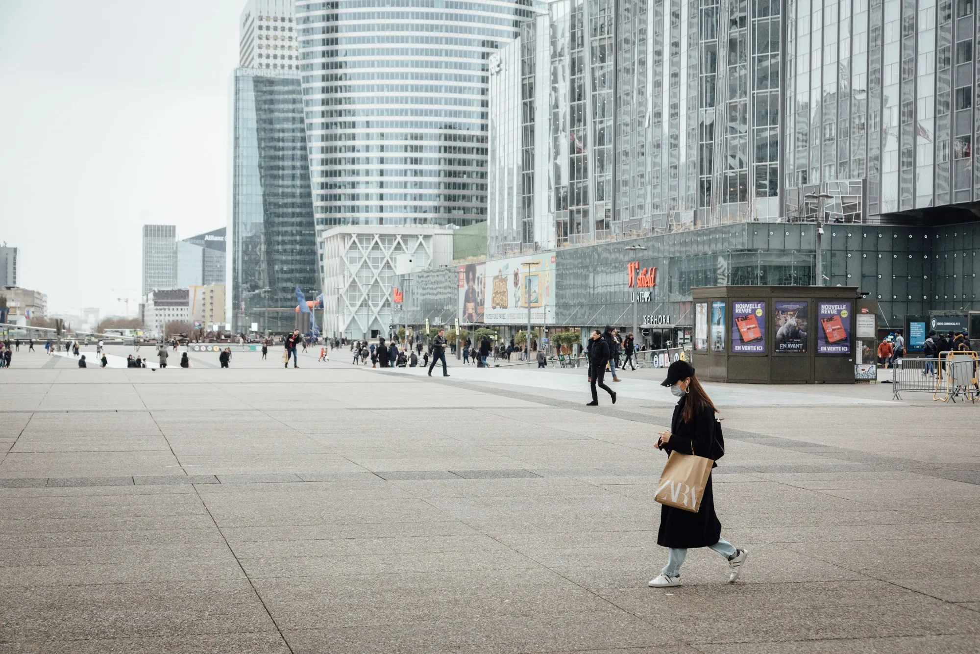 A pedestrian wearing a protective face mask carries a Zara fashion store carrier bag in the La Defense business district of Paris.