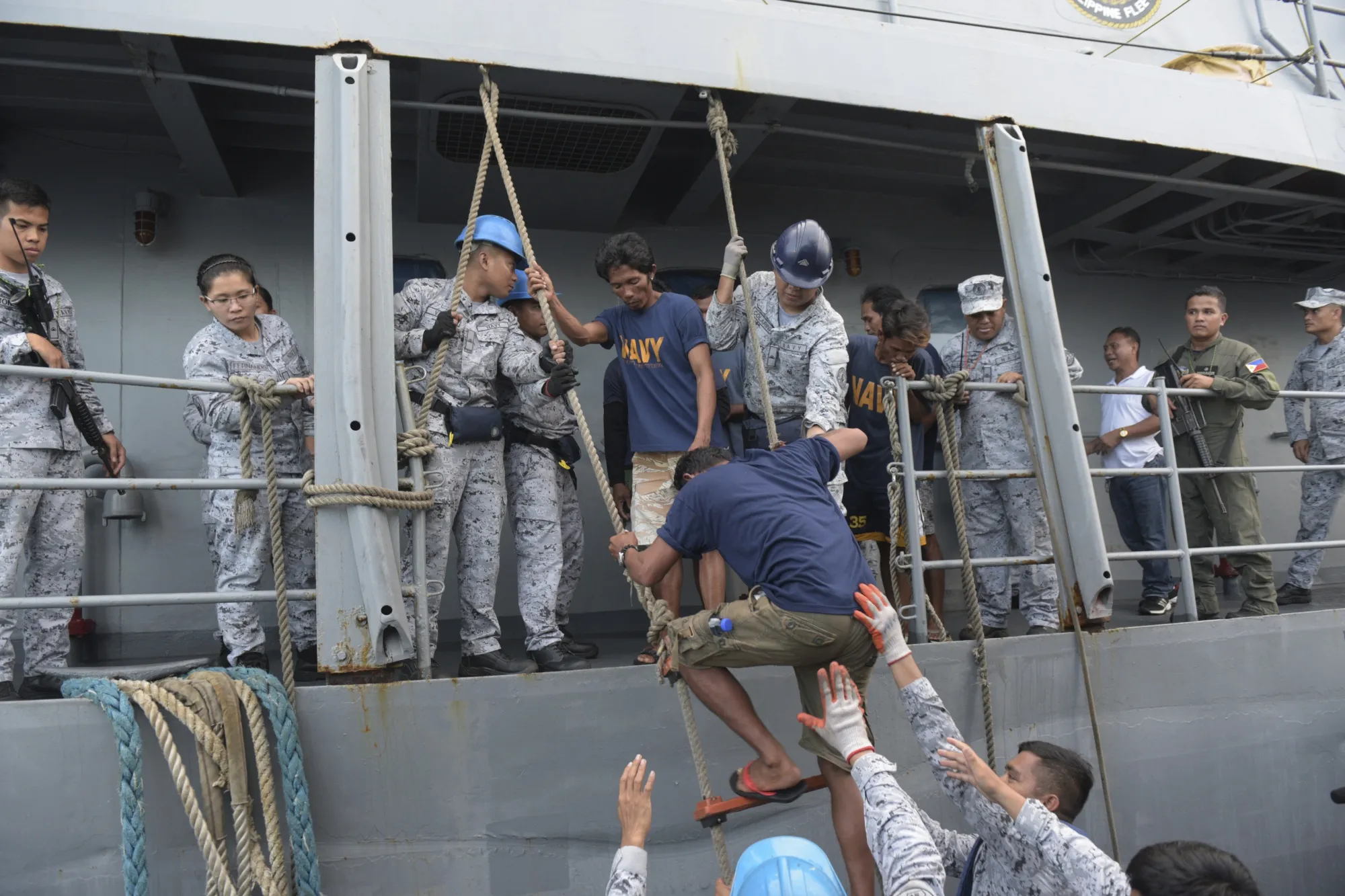 Rescued Filipino fishermen board a ship as they head back to shore on June 14.