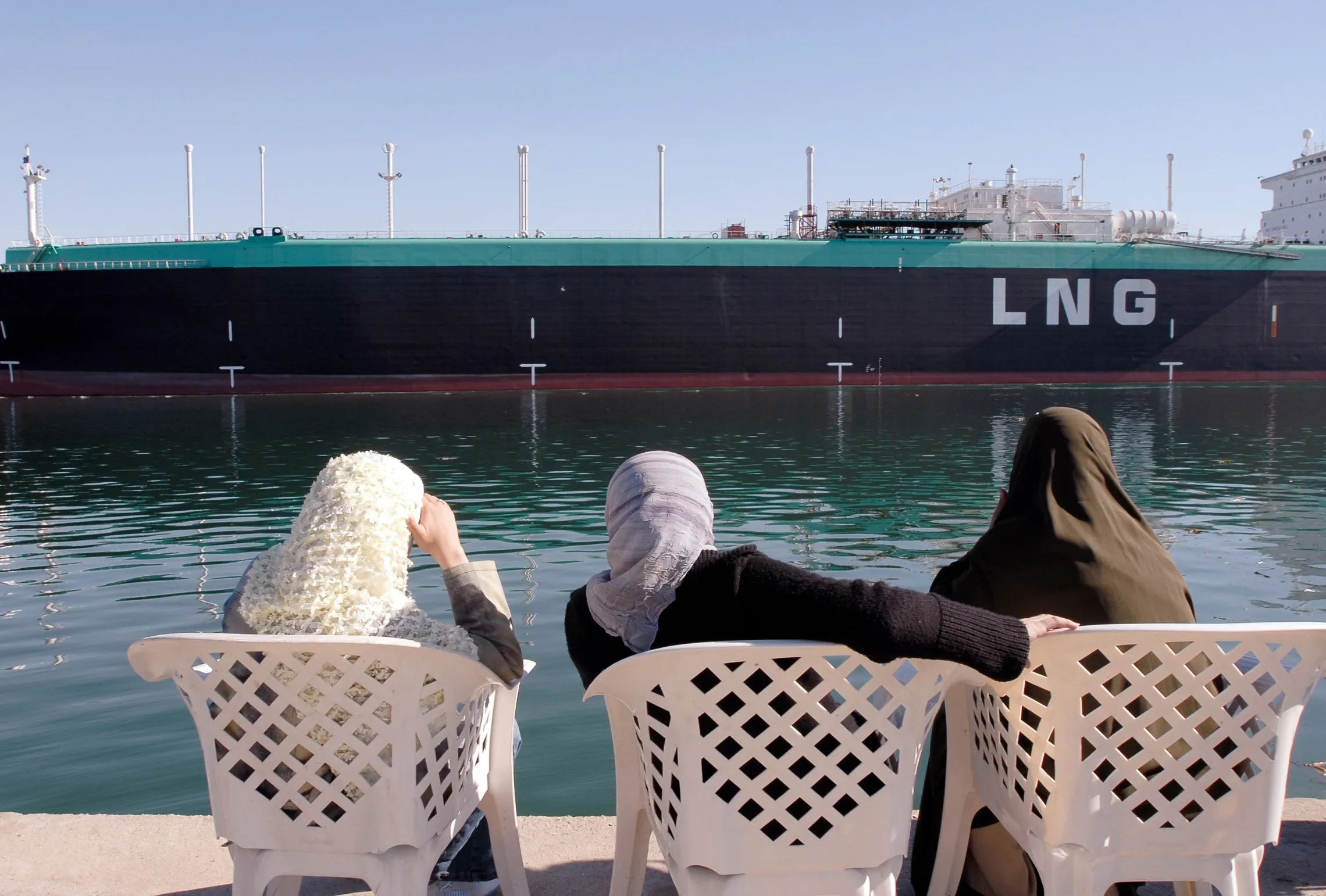 Women observe&nbsp;a Liquefied Natural Gas (LNG) tanker as it sails&nbsp;on the Suez Canal, Egypt.&nbsp;
