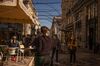 A waitress serves customers at a cafe terrace in the Chiado district of Lisbon.