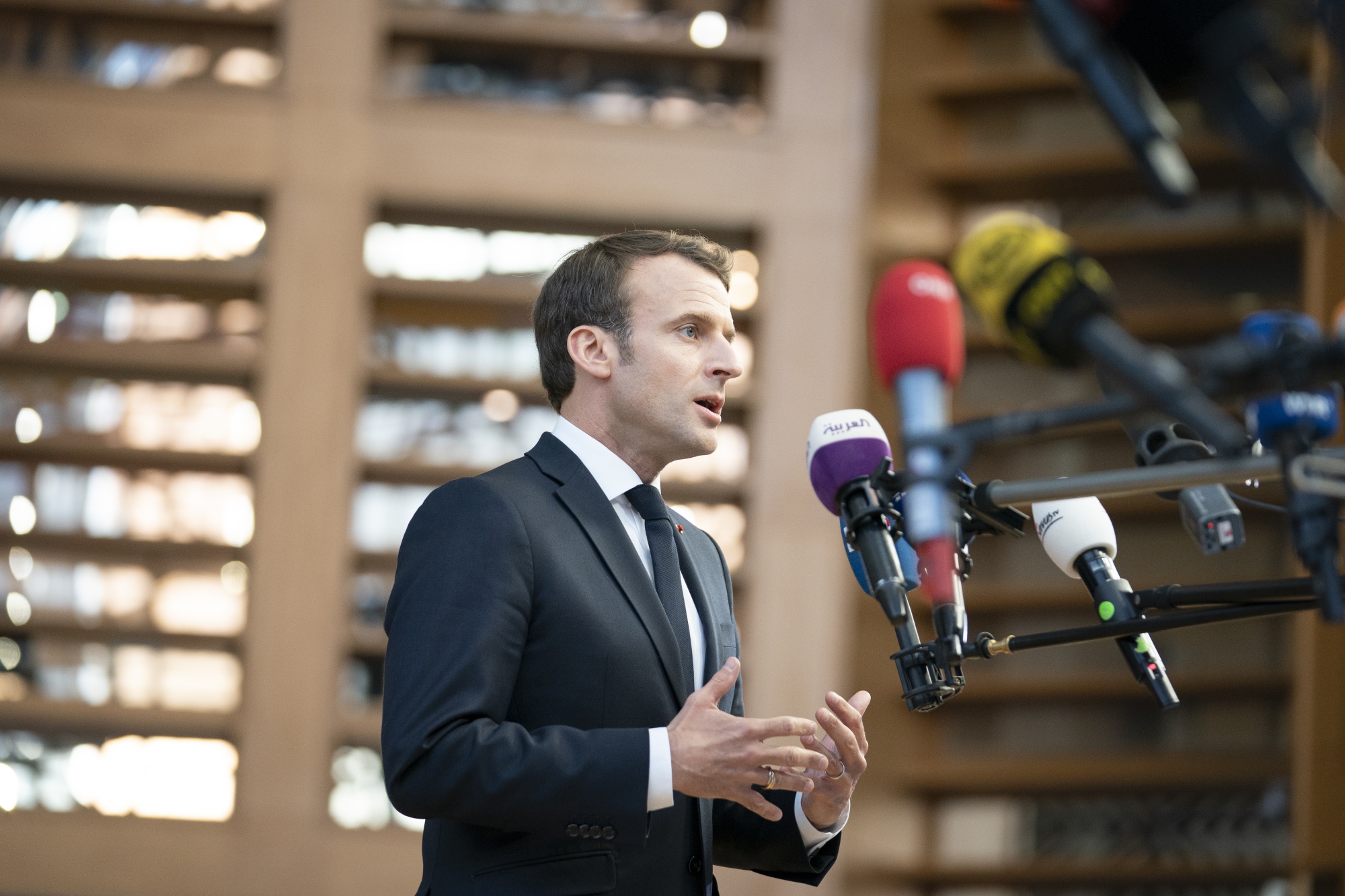 Emmanuel Macron speaks to journalist as he arrives for a European Union leaders summit in the Europa building in Brussels on April 10, 2019.