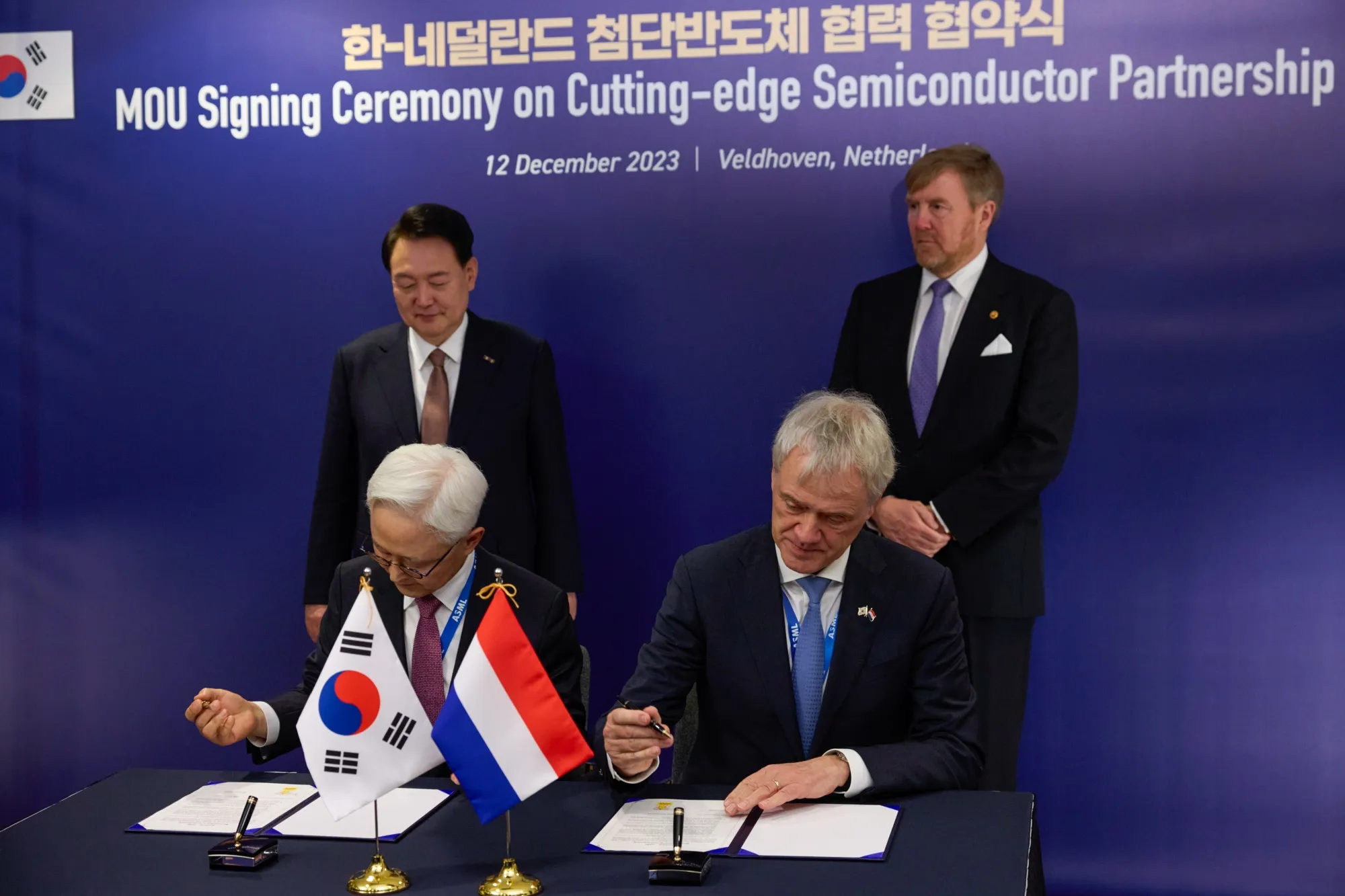 Samsung Semiconductor CEO Kyung Kyehyun and ASML CEO Peter Wennink sign a memorandum of understanding watched by Yoon Suk Yeol, South Korea’s president and King Willem-Alexander of the Netherlands during a visit to the ASML headquarters in Veldhoven on Dec. 12.