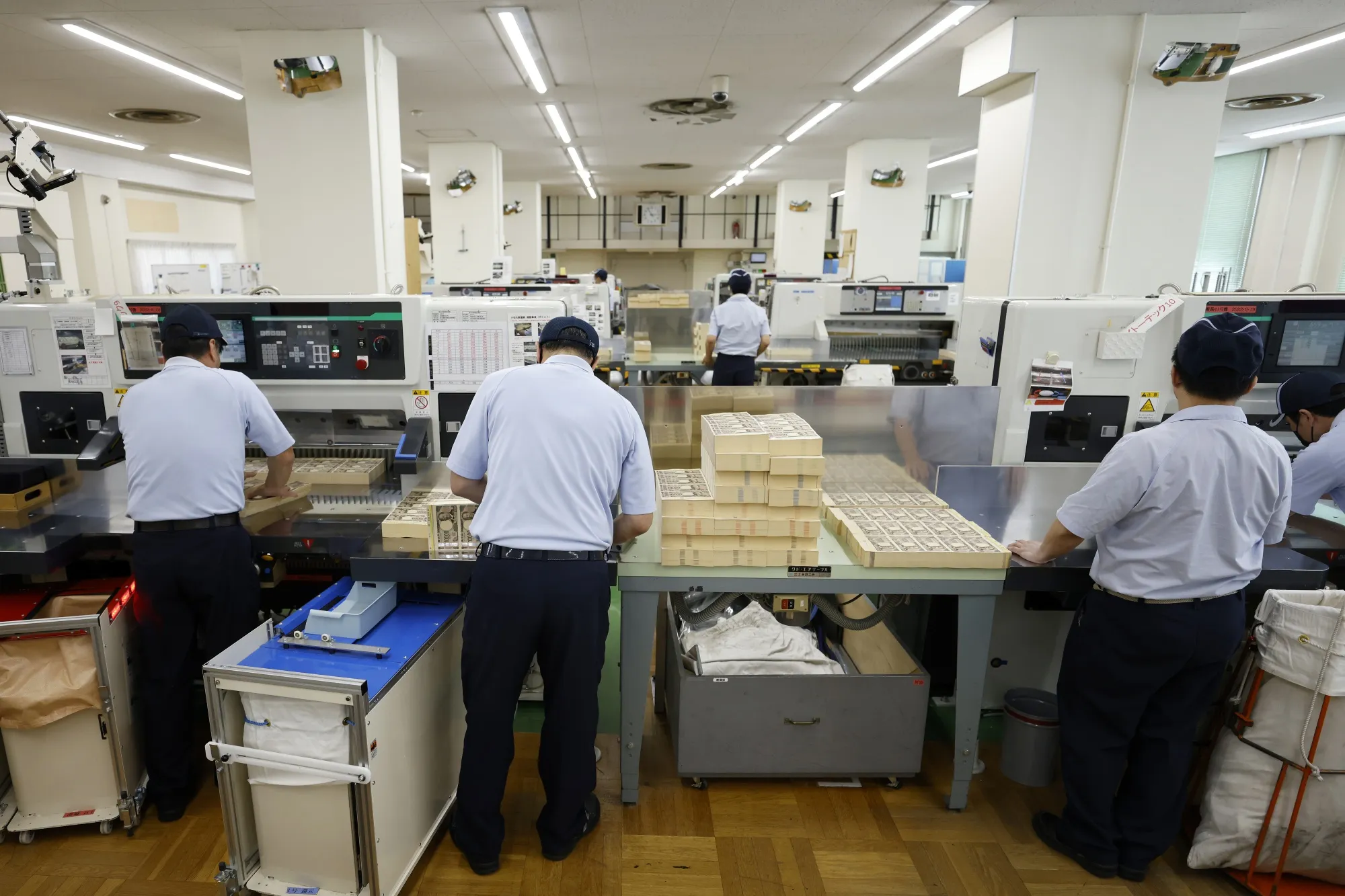 Employees handle sheets of&nbsp;Japanese 10,000 yen banknotes at the National Printing Bureau Tokyo plant in Tokyo, Japan.