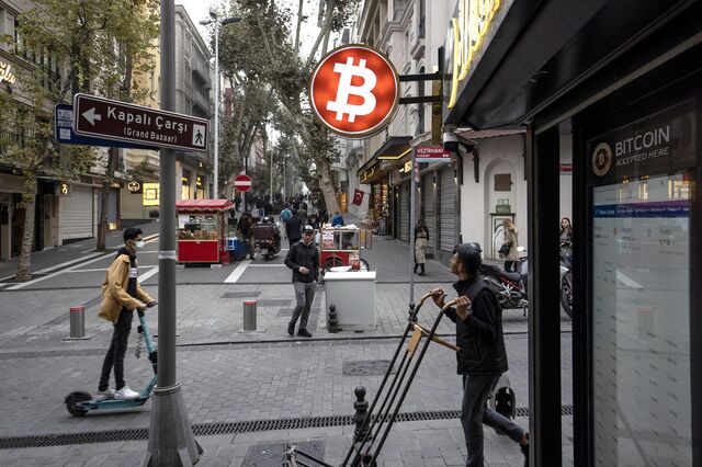 A bitcoin logo sign protrudes from a cryptocurrency exchange kiosk in istanbul, turkey, on monday, nov. 8, 2021. Bitcoin and ether hit all-time highs in a cryptocurrency rally that some analysts attributed partly to the search for a hedge against inflation.