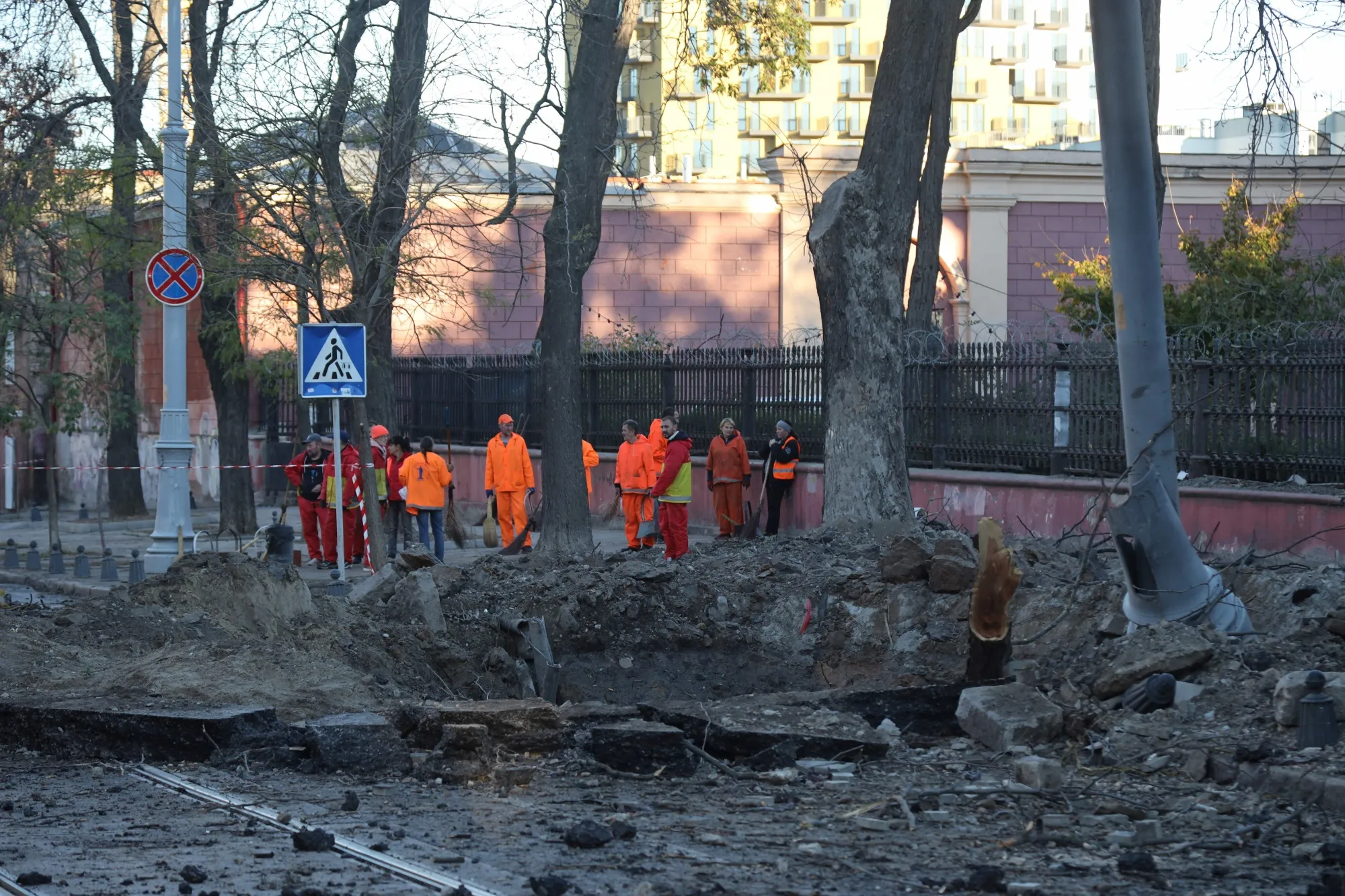 Workers stand by a crater&nbsp;following a strike the day before in Odesa, Ukraine, on Nov. 6.