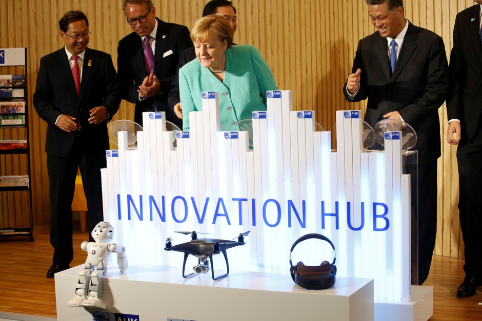 German Chancellor Angela Merkel looks at a robot as she attends the opening of AHK Innovation Hub in Shenzhen, China, May 25, 2018.