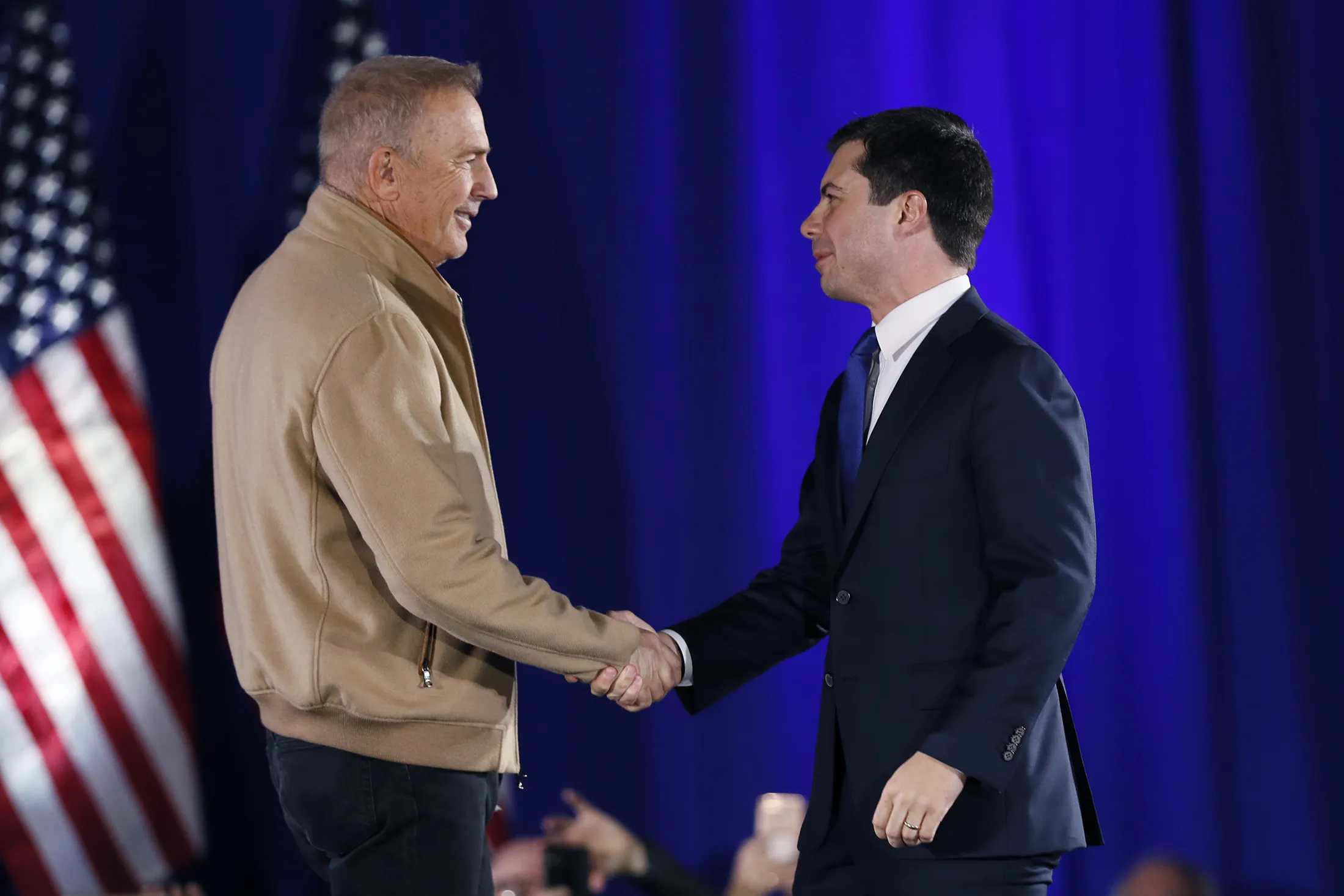 ]Pete Buttigieg greets actor Kevin Costner, left, during a campaign event in Iowa on Dec. 22.