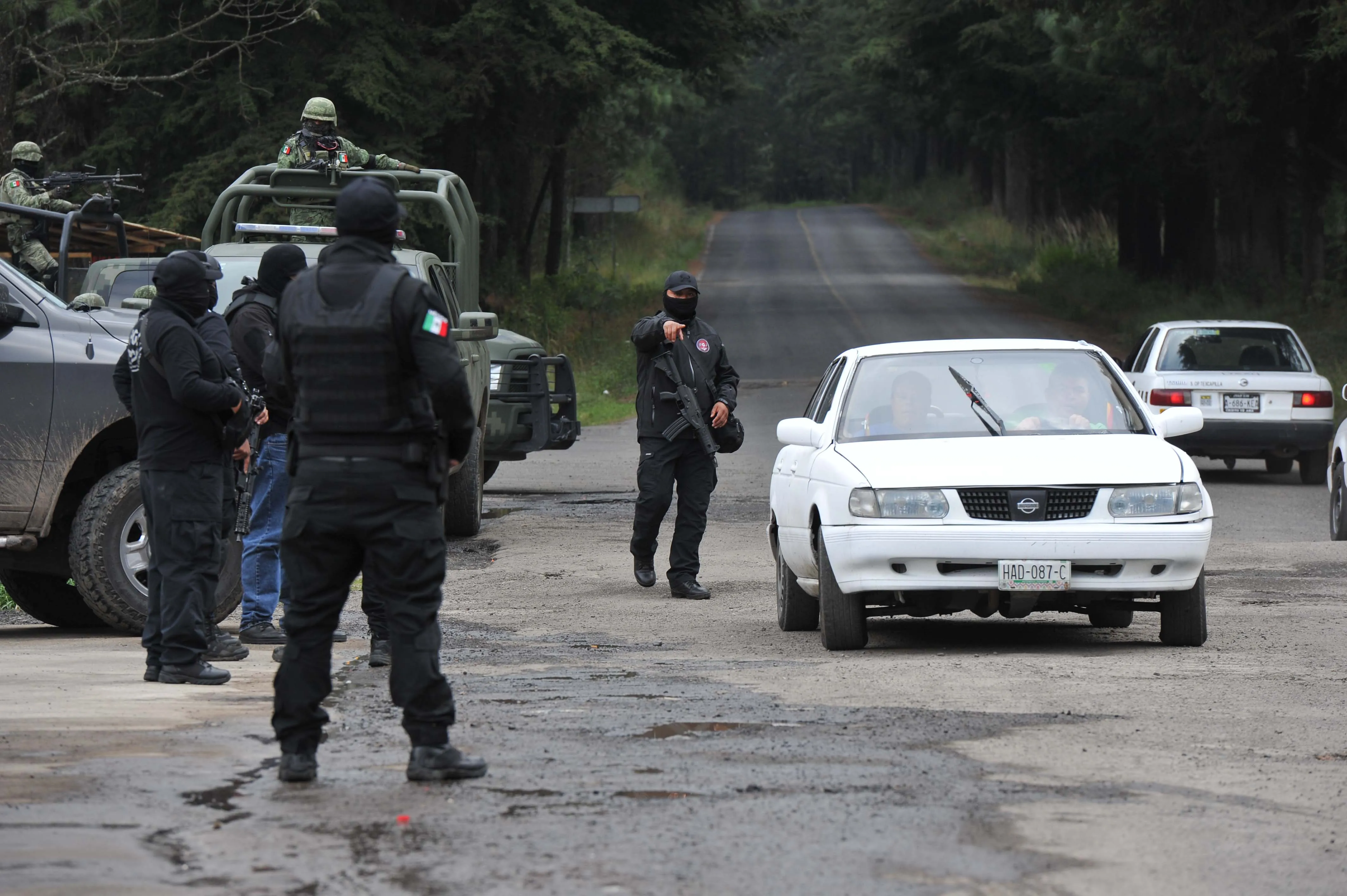 Police and military personnel stop a vehicle as they search&nbsp;in Texcaltitlan, Mexico.