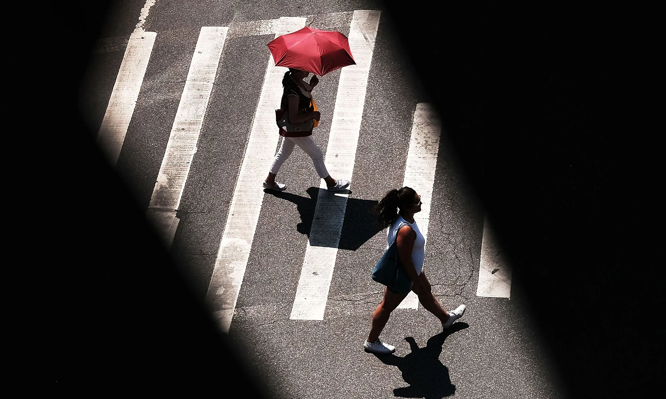 A woman uses an umbrella to keep cool in the mid-day heat on July 6, 2016 in New York City.
