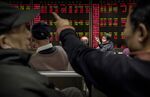 Chinese day traders watch the stock tickers on a board at a brokerage firm in Beijing, China.
