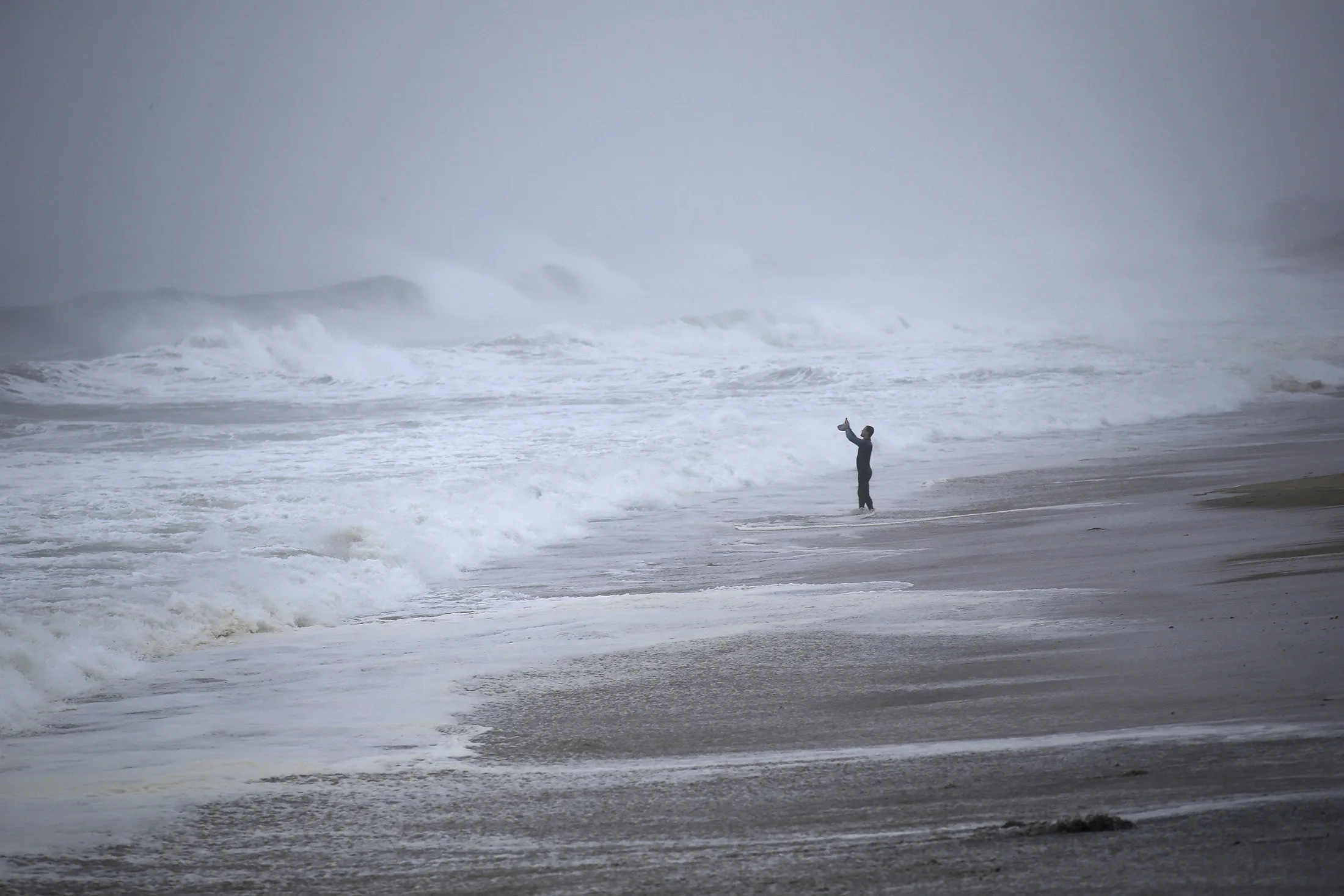 A resident takes photos of the waves as Tropical Storm Henri approaches Westerly, Rhode Island, on Aug. 22.