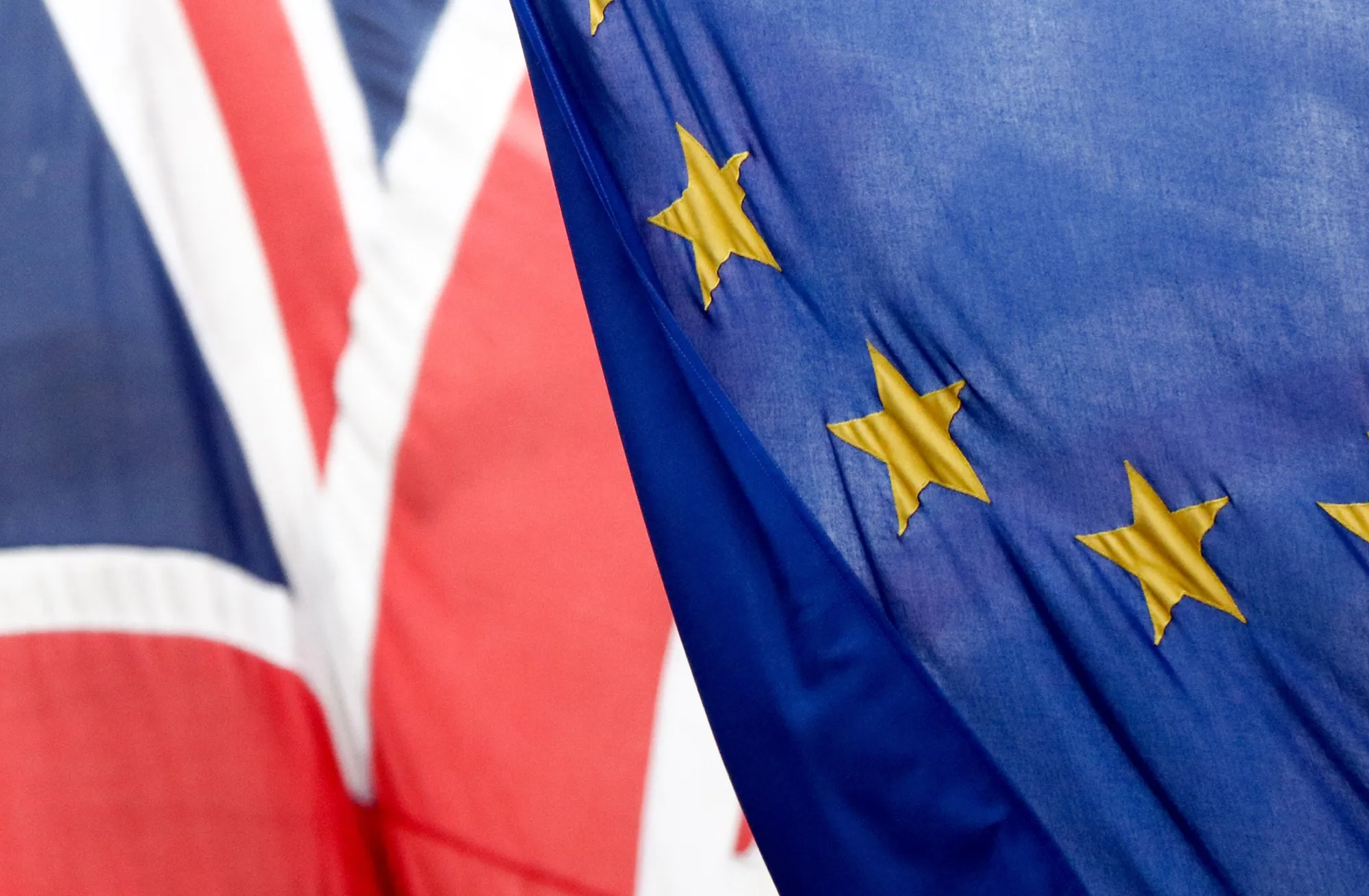 A British Union flag, commonly known as a Union Jack, left, flies next to a European Union (EU) flag, in London, U.K., on Wednesday, Feb. 17, 2016. German Chancellor Angela Merkel threw her political muscle behind the push for a deal to keep the U.K. in the European Union as diplomats worked to bridge the remaining differences between its members.
