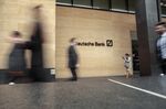 Pedestrians pass the offices of Deutsche Bank AG in London.