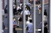 Pedestrians wearing protective masks are reflected on a glass wall in the Shinjuku district of Tokyo, Japan, on Friday, July 10, 2020. Japan is forging ahead with further steps to re-open the economy even as daily coronavirus cases continue to climb, with local media reporting Tokyo posting a daily record of over 240 infections on Friday.
