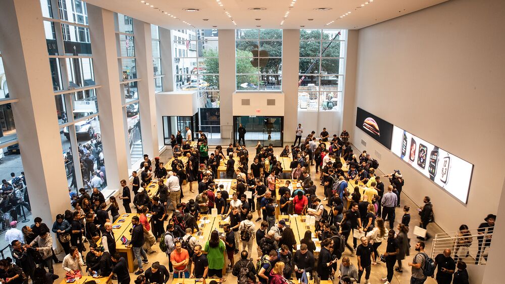 Employees assist customers with Apple Inc. products during a sales launch at a store in New York.