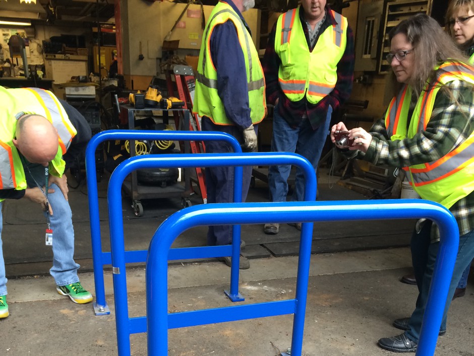 People examine Portland's new security racks, which include unseen cables that bike thieves have difficulty sawing through.