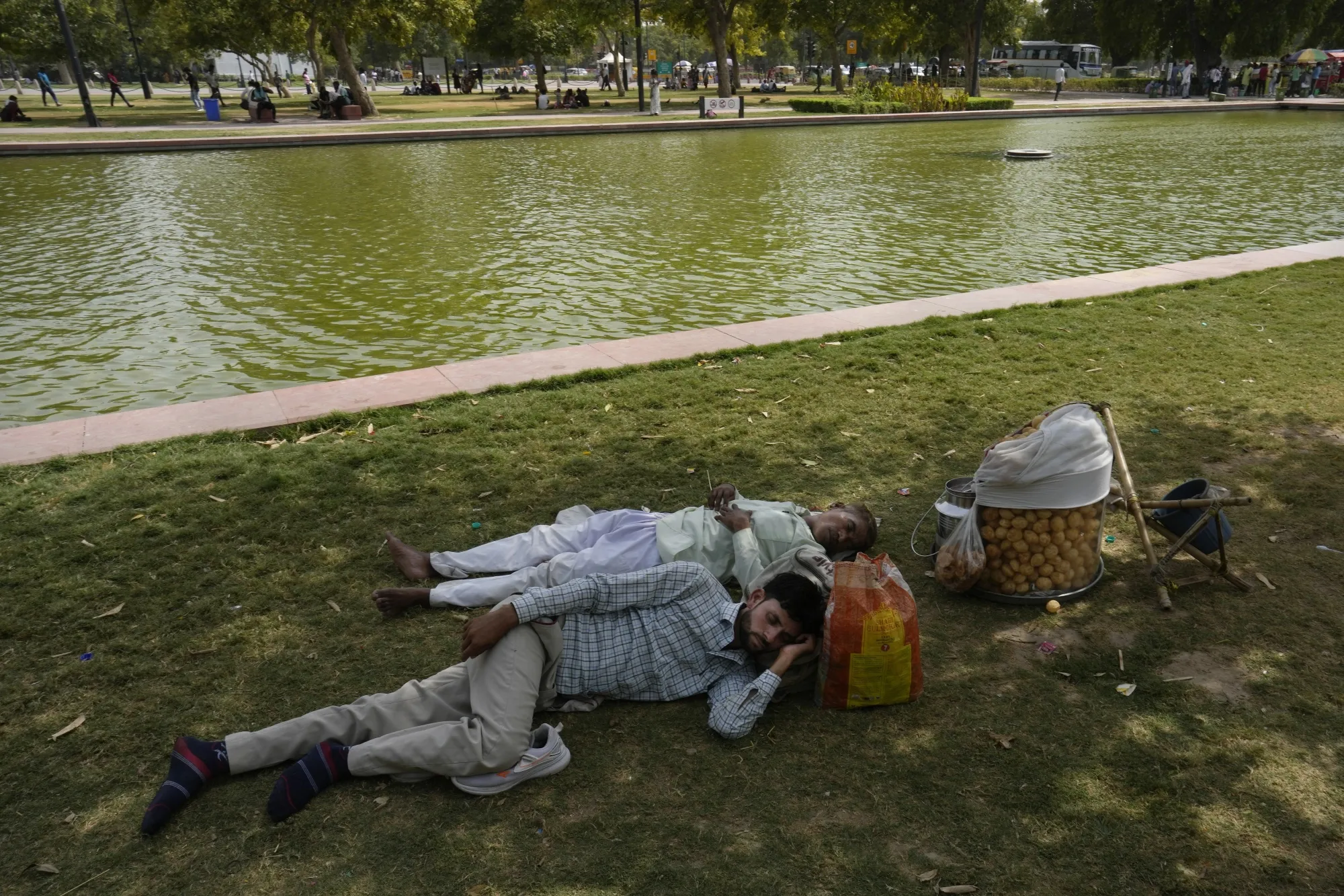 People shelter from the sun in the shade of a tree in New Delhi on June 18.