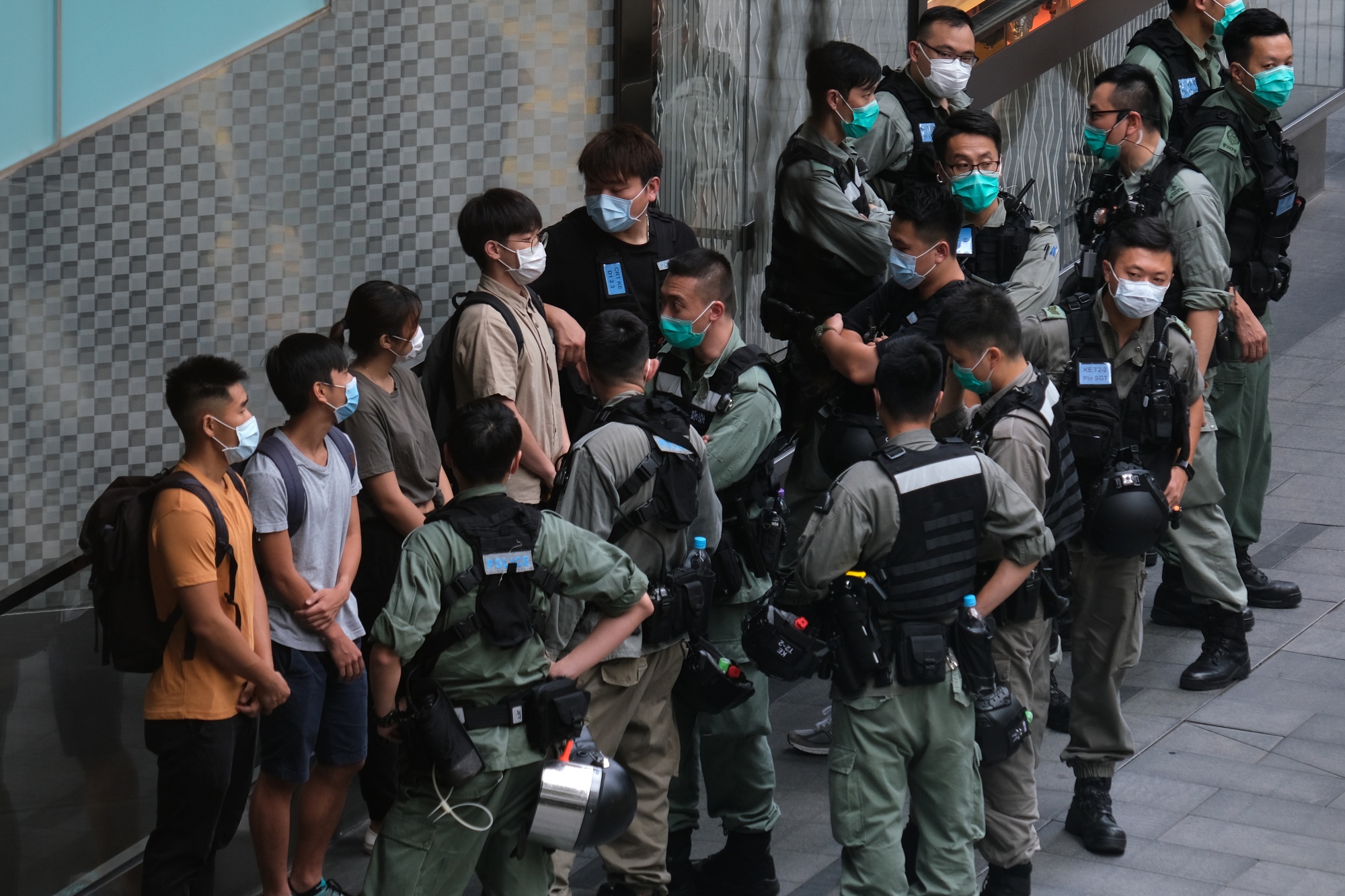Riot police stop and search people in front of a Louis Vuitton luxury goods store,&nbsp;ahead of an anticipated protest in Hong Kong, on May 27.