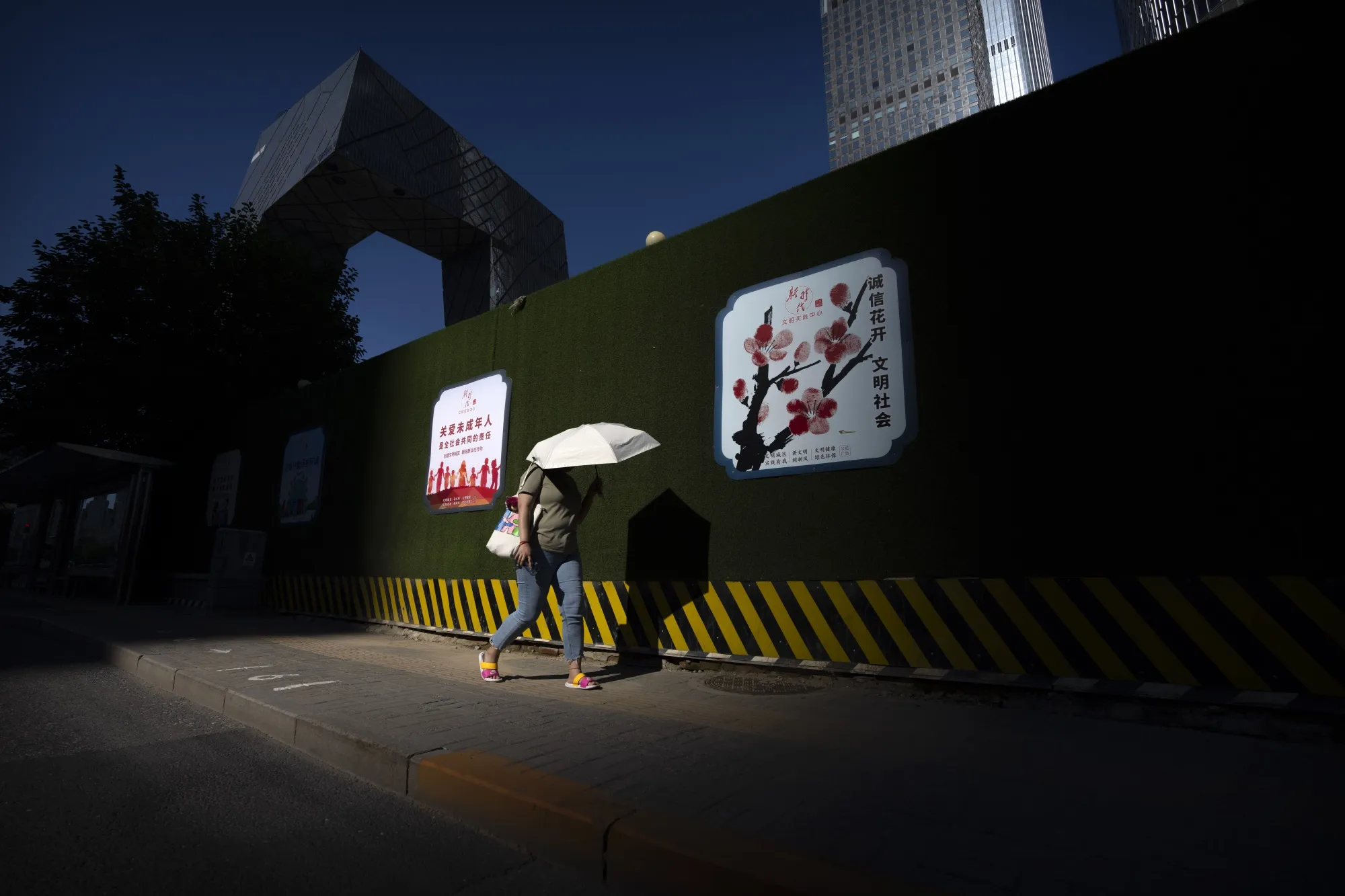 A woman shields from the sun in Beijing’s central business district.