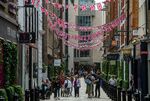 Shoppers walk along a street in Covent Garden, London, UK.