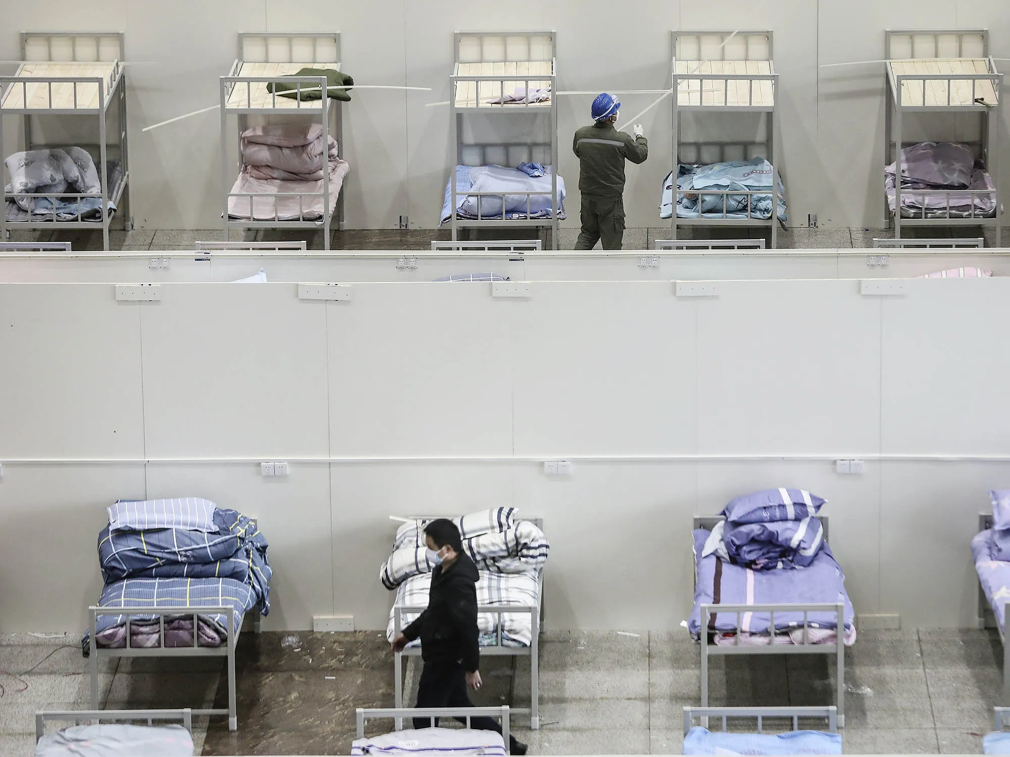 Workers prepare a temporary hospital at the Wuhan International Conference and Exhibition Center .