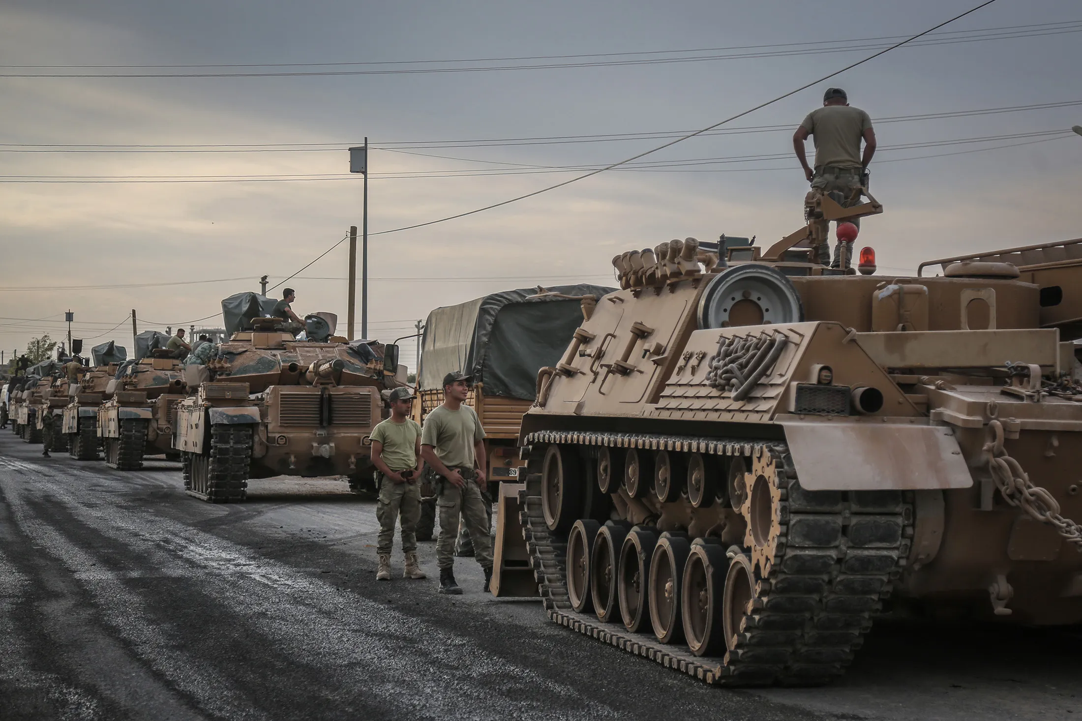 Soldiers and military vehicles are deployed at a staging area for the Turkish Armed Forces and the Turkish-backed Syrian National Army in the town of Akcakale along the border with the Syria on Oct. 11.