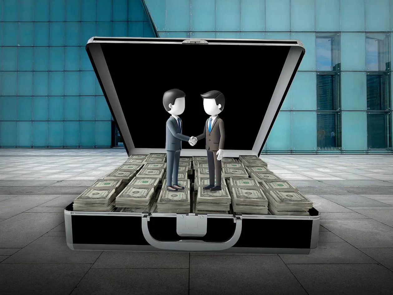 COVER_HAND_SHAKES_ON_MONEY_BRIEFCASE_DEALS