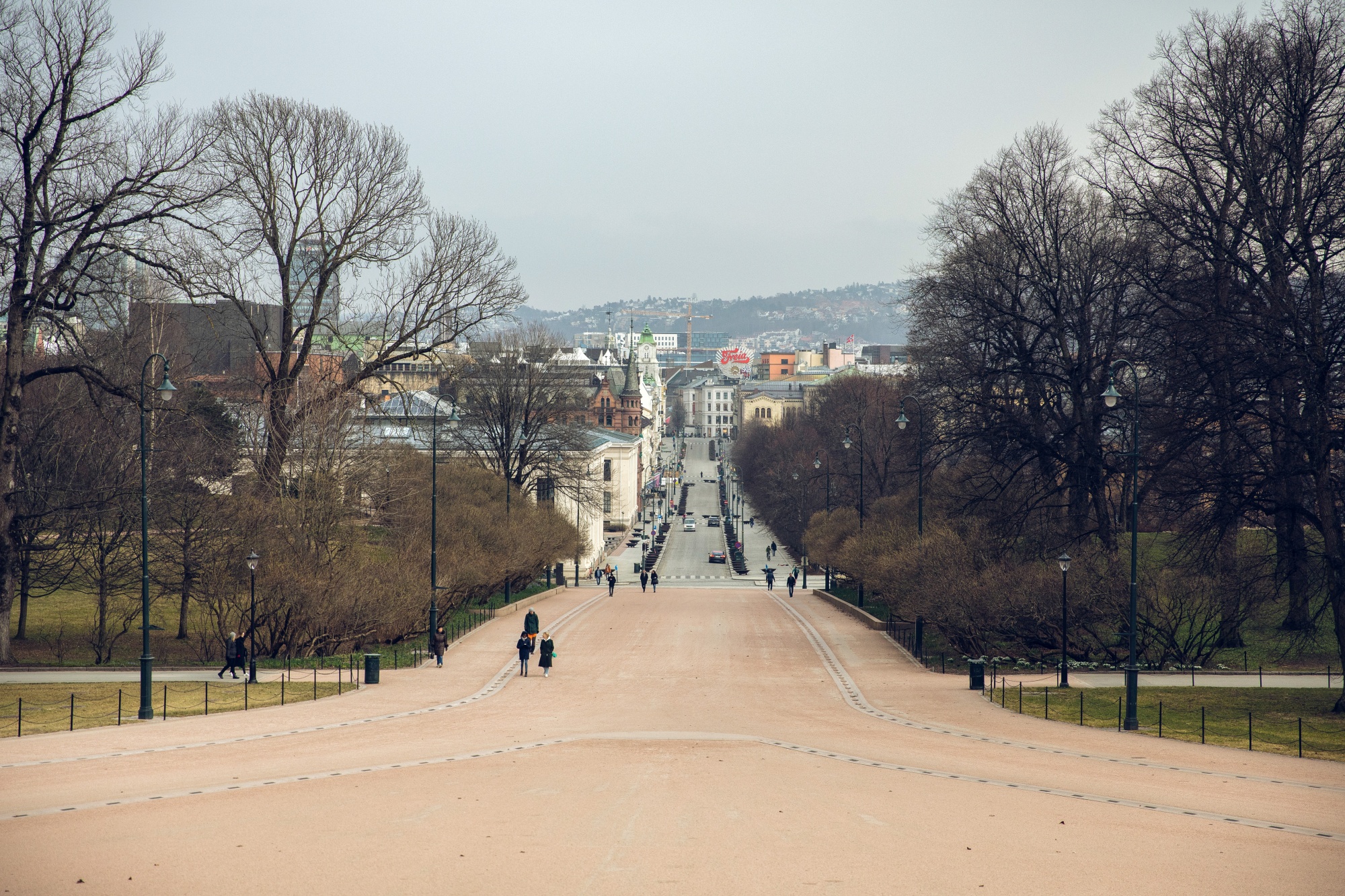 Pedestrians walk towards the Royal Palace in Oslo.