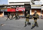 Israeli army soldiers walk during clashes with Palestinian protesters in Hebron, West Bank. 