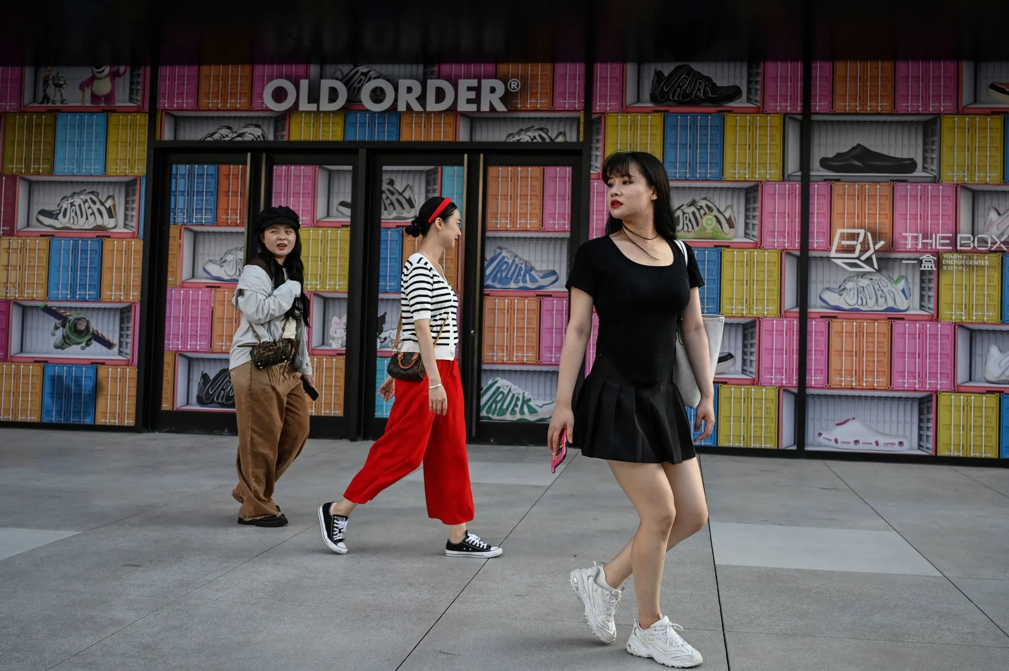 People walk outside a shopping mall in Beijing on Aug.&nbsp;16.