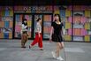 People walk outside a shopping mall in Beijing on Aug.&nbsp;16.
