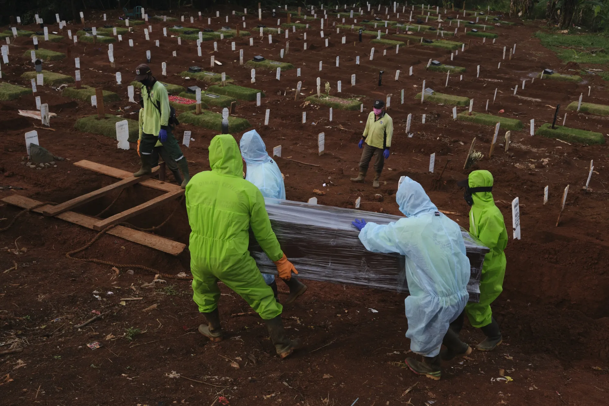 Cemetery workers place a coffin into a newly dug grave for Covid-19 victims in Jakarta on April 30.