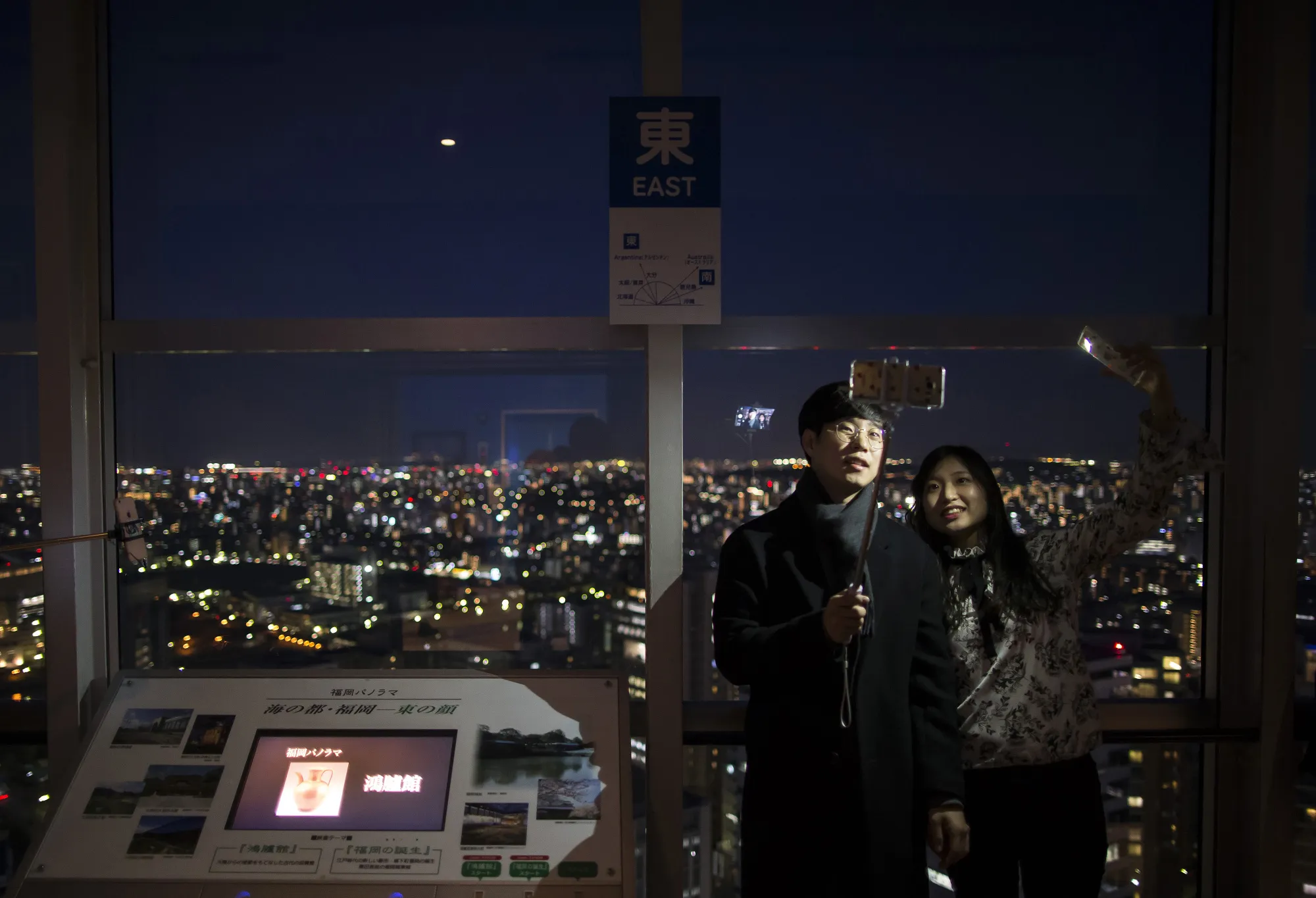 A South Korean couple pose for a selfie photograph on the observation deck of the Fukuoka Tower in Fukuoka.