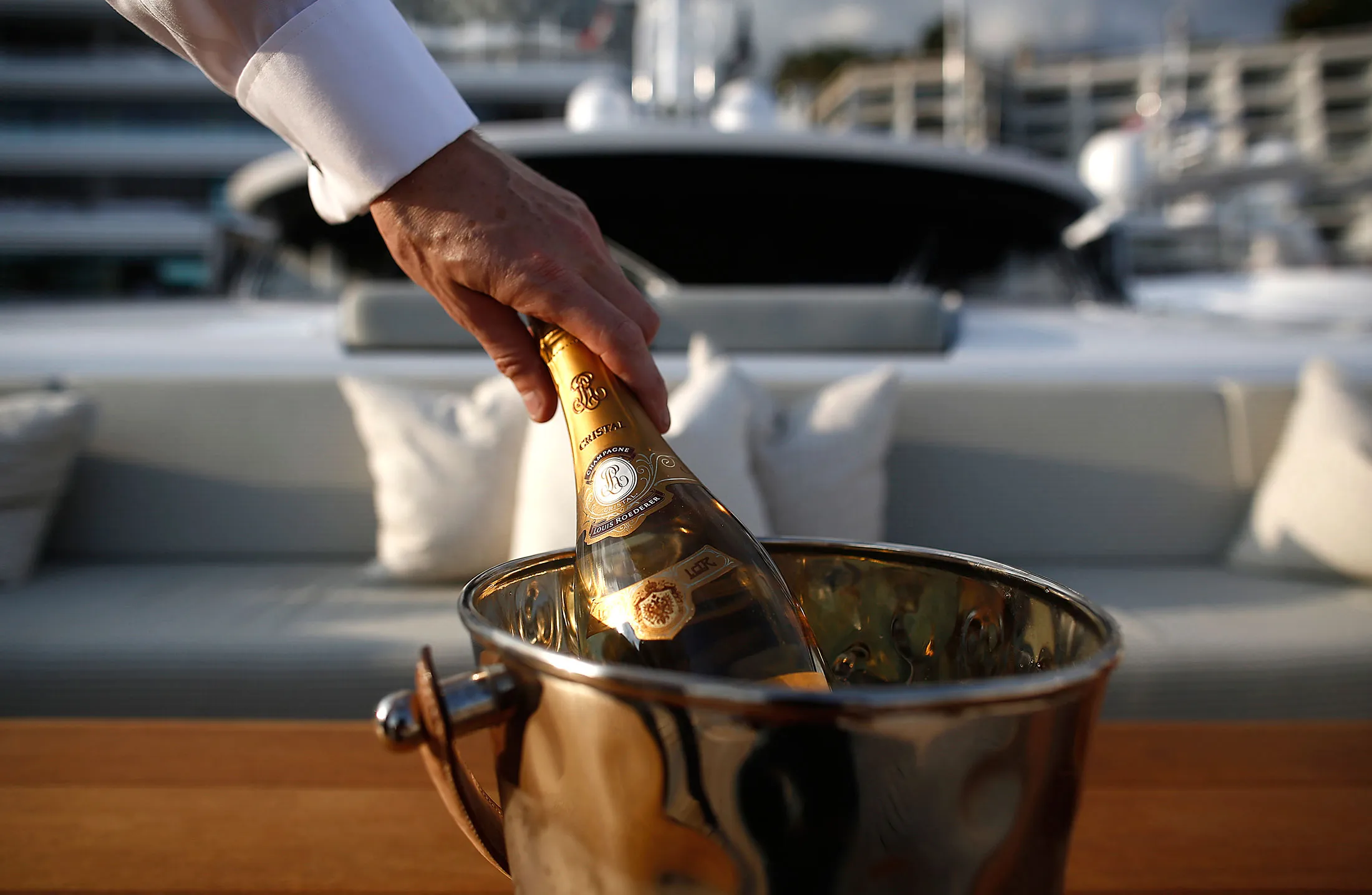 A crew member holds a magnum of Tattinger champagne during the Monaco Yacht Show.
