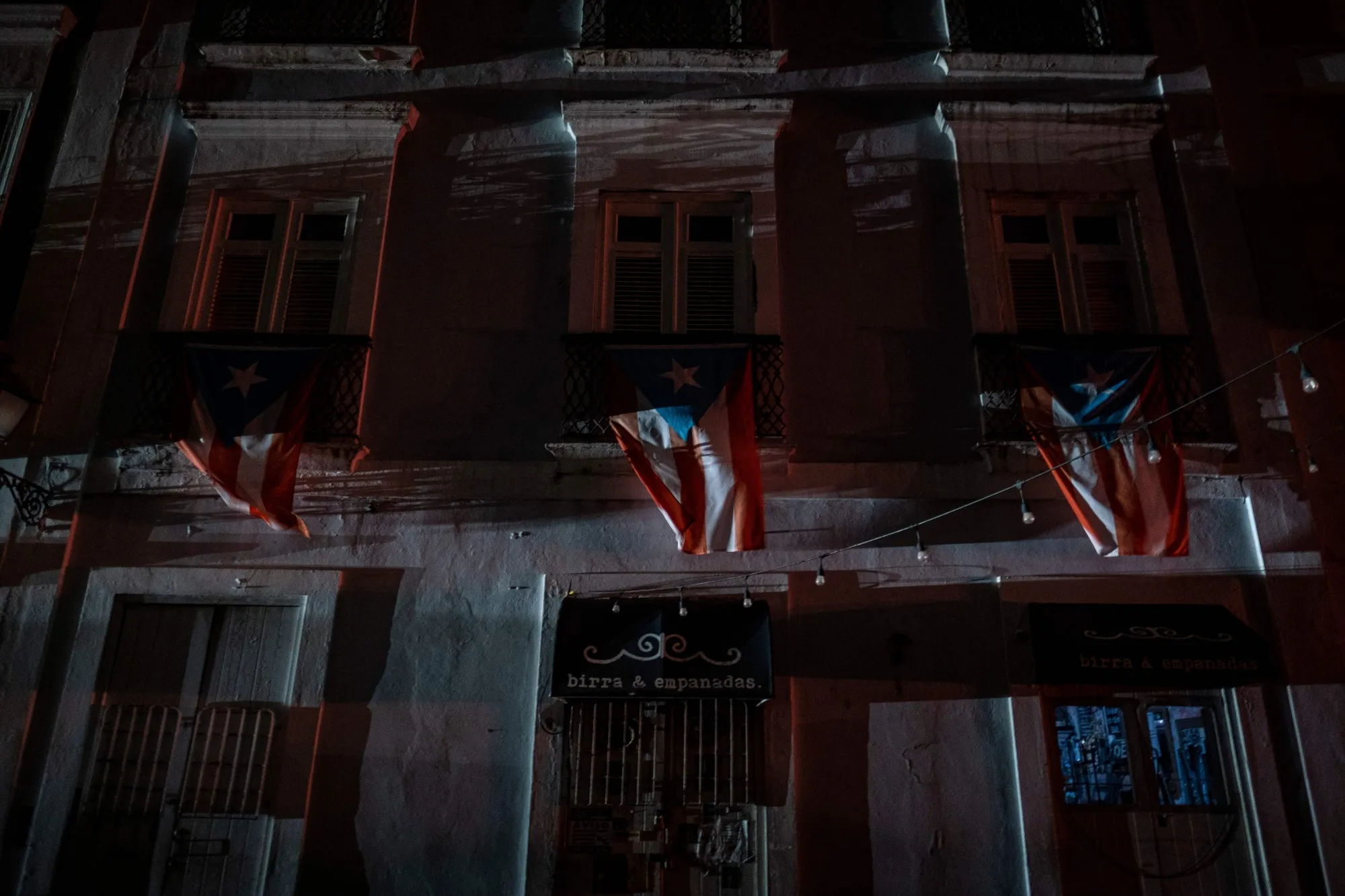Puerto Rican flags hang from a balcony in San Juan, Puerto Rico after a major power outage hit the island on April 6, 2022.